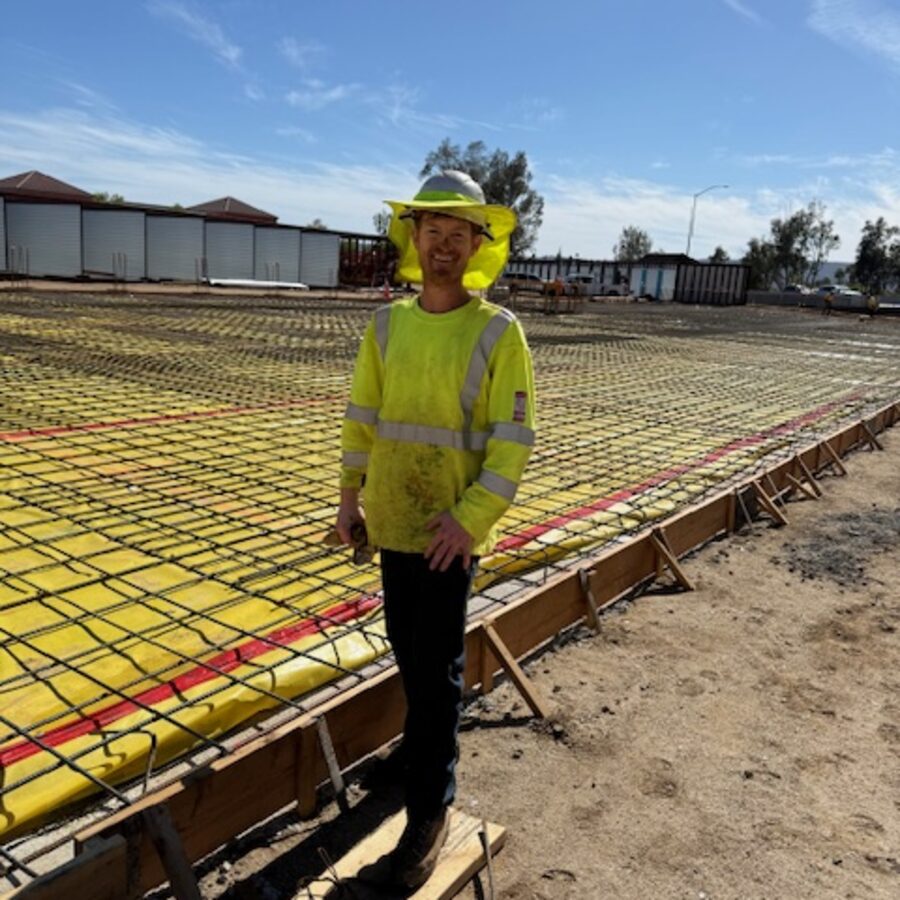 Alex Jay in a hi-vis shirt and hard hat on a construction site
